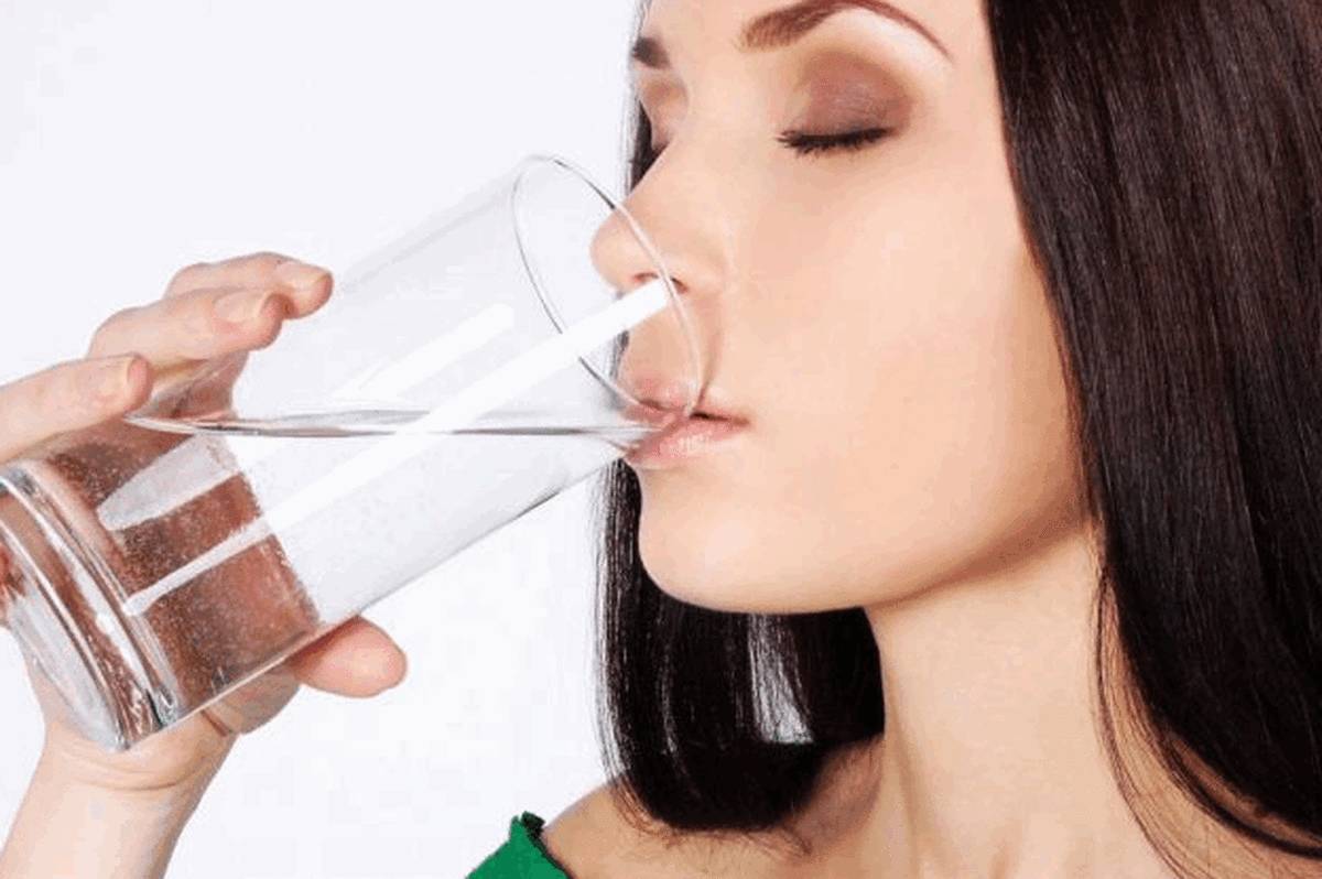 Девушка пьет воду для УЗИ мочевого пузыря